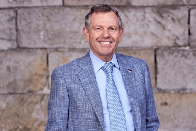 A man stands in a blue suit