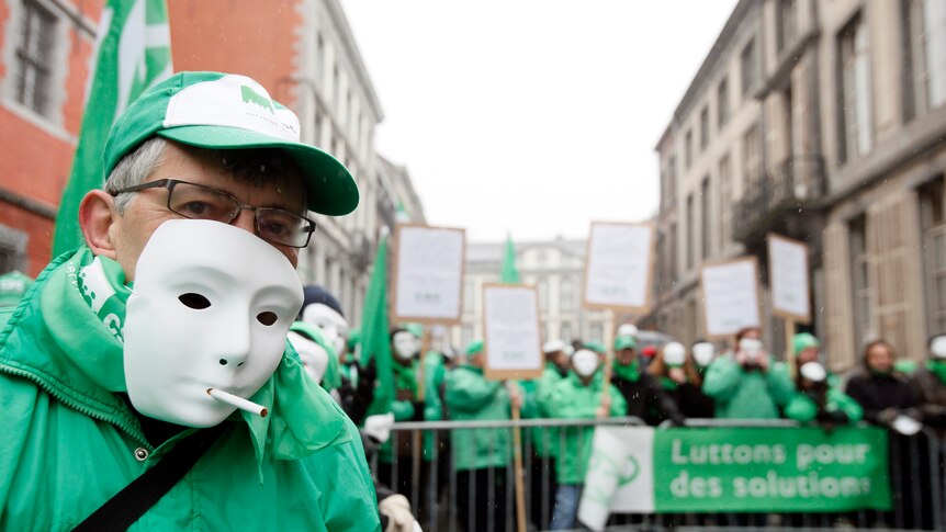 Belgian workers stage a protest in front of the prime minister's house