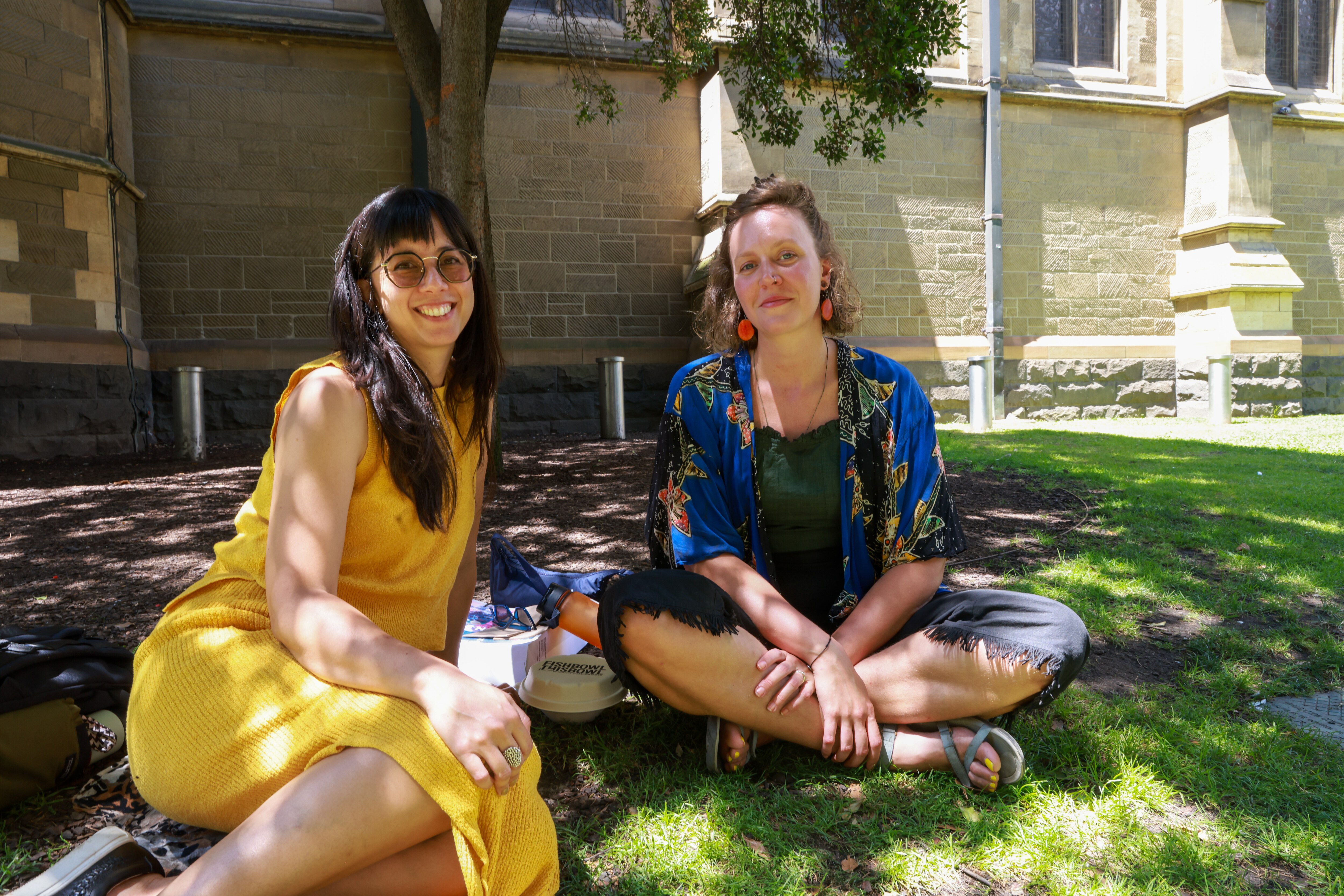 Faded social distance stickers on the footpath and people walking with masks as they pass hand sanitiser stations.