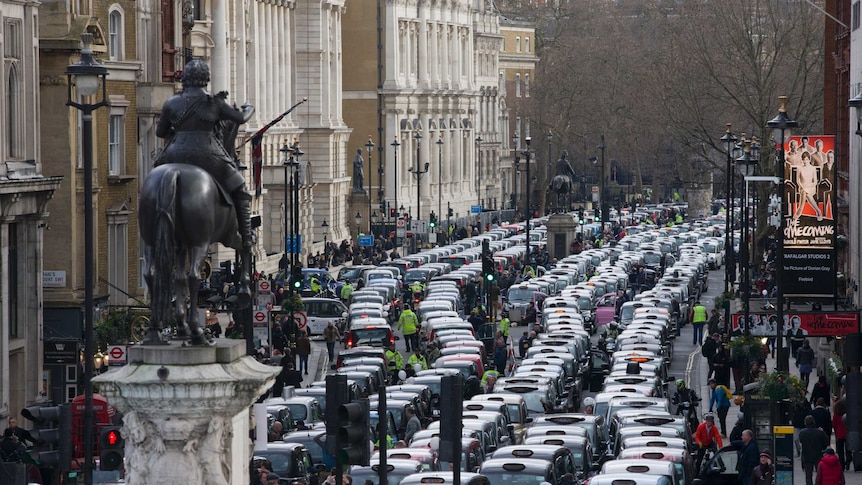 Taxi drivers block streets as they demonstrate in central London.