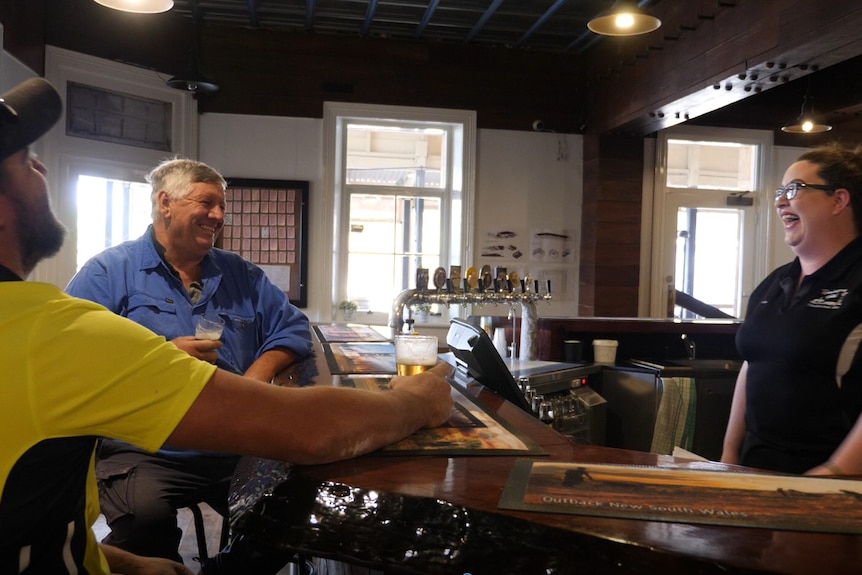 Bartender Leona Keane laugh with two men who work for Barlow Builders at the Tibooburra Hotel. 