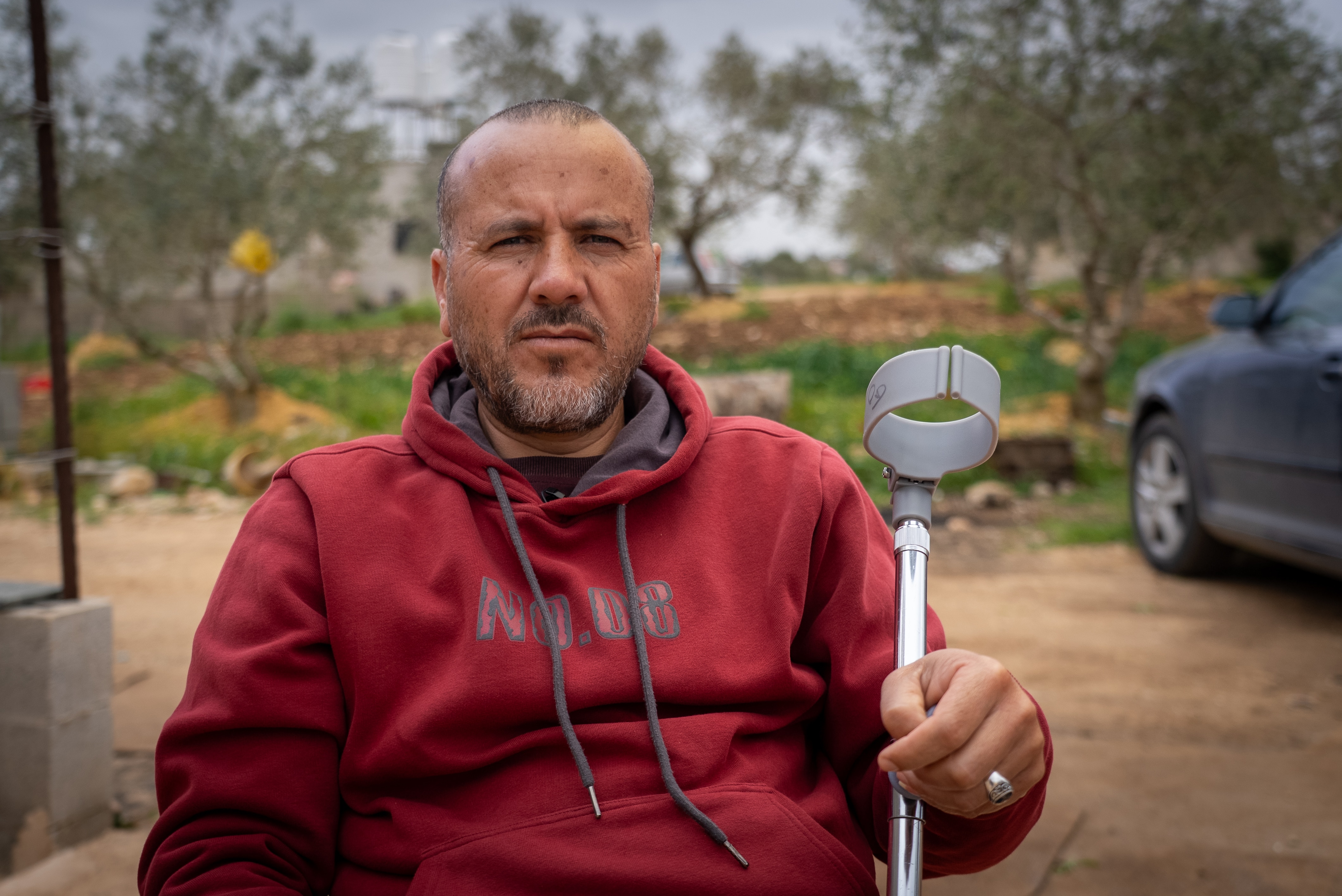 Jamil Muammar sits holding a crutch.