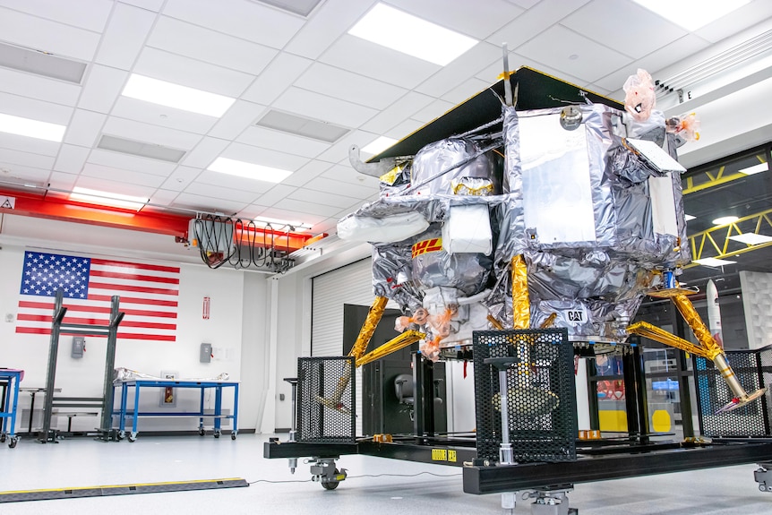 A space craft in a room with an American flag on the wall