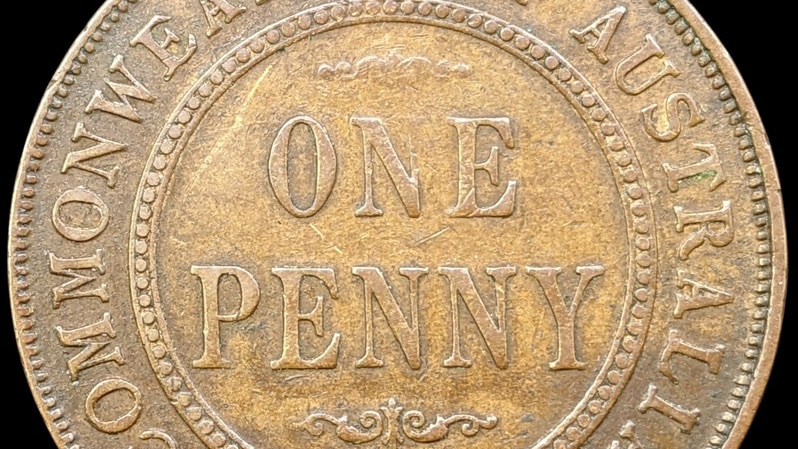 A gold coloured coin with the words ONE PENNY on it