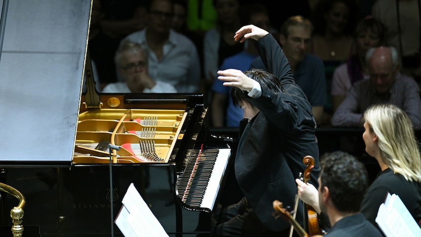 Hands raised about to strike a chord, pianist Nobuyuki Tsujii playing Rachmaninov's Piano Concerto No. 3.
