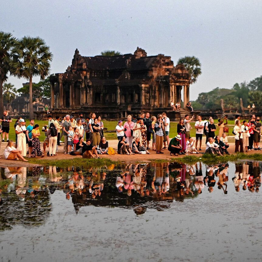 Tourists gather by the water at the Angkor Wat temple complex in Cambodia.