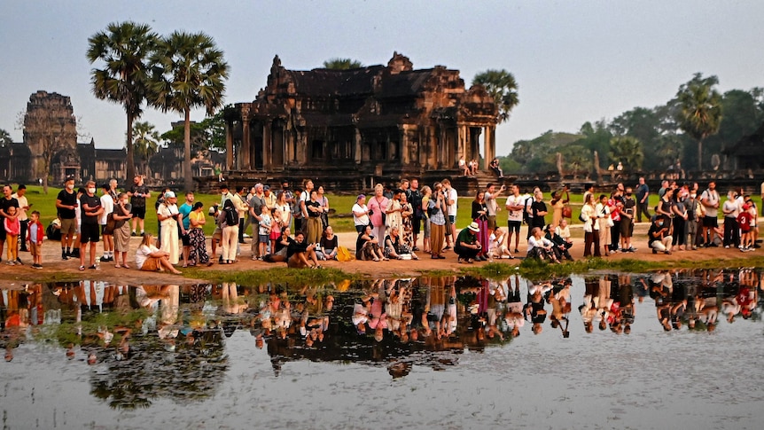 Tourists gather by the water at the Angkor Wat temple complex in Cambodia.