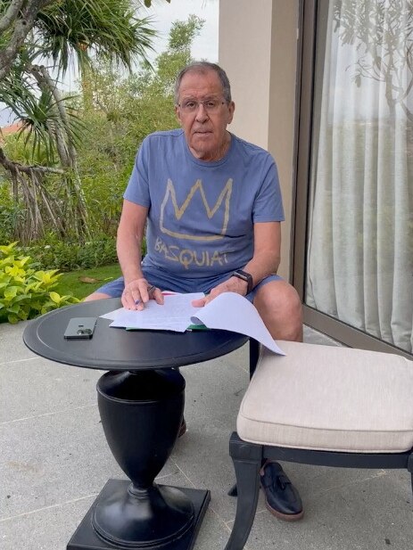 Sergei Lavrov sitting at a table dressed in shorts and a tee 