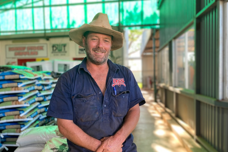 Un homme en uniforme bleu avec un chapeau est assis