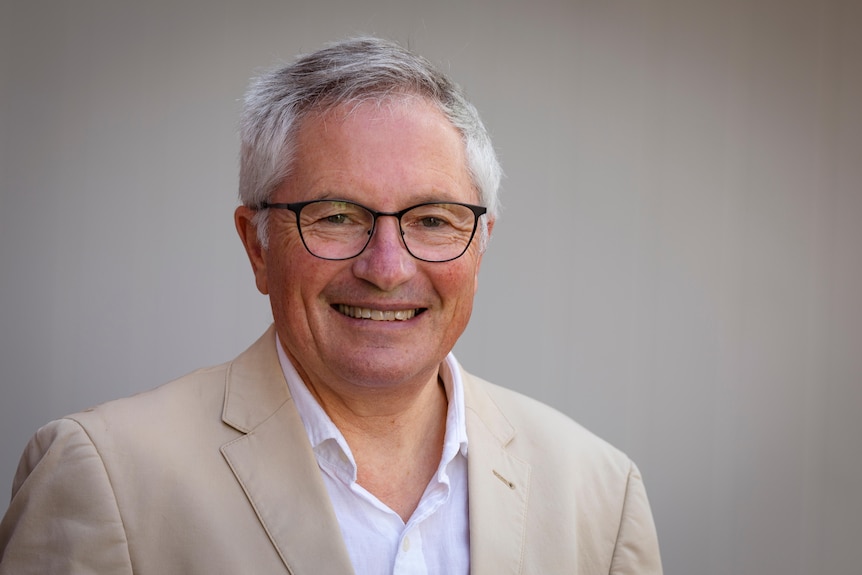 David Hayward smiles, dressed in a shirt and jacket.