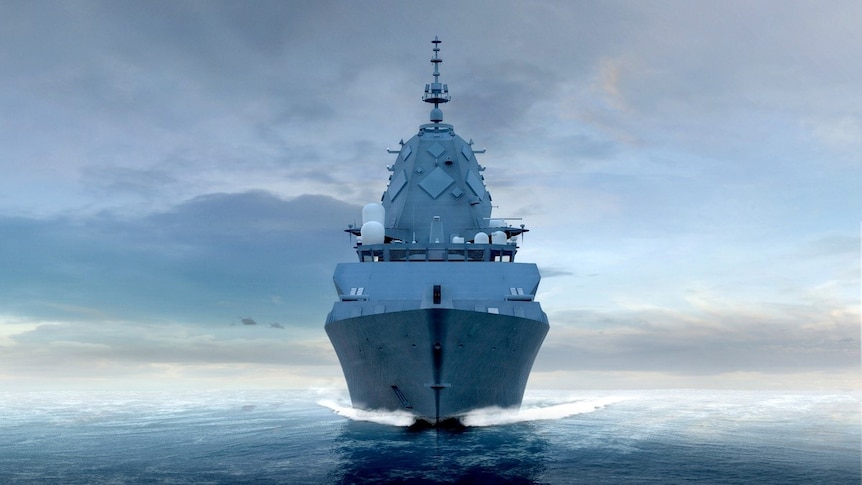 A large warship sails towards the camera through open waters.