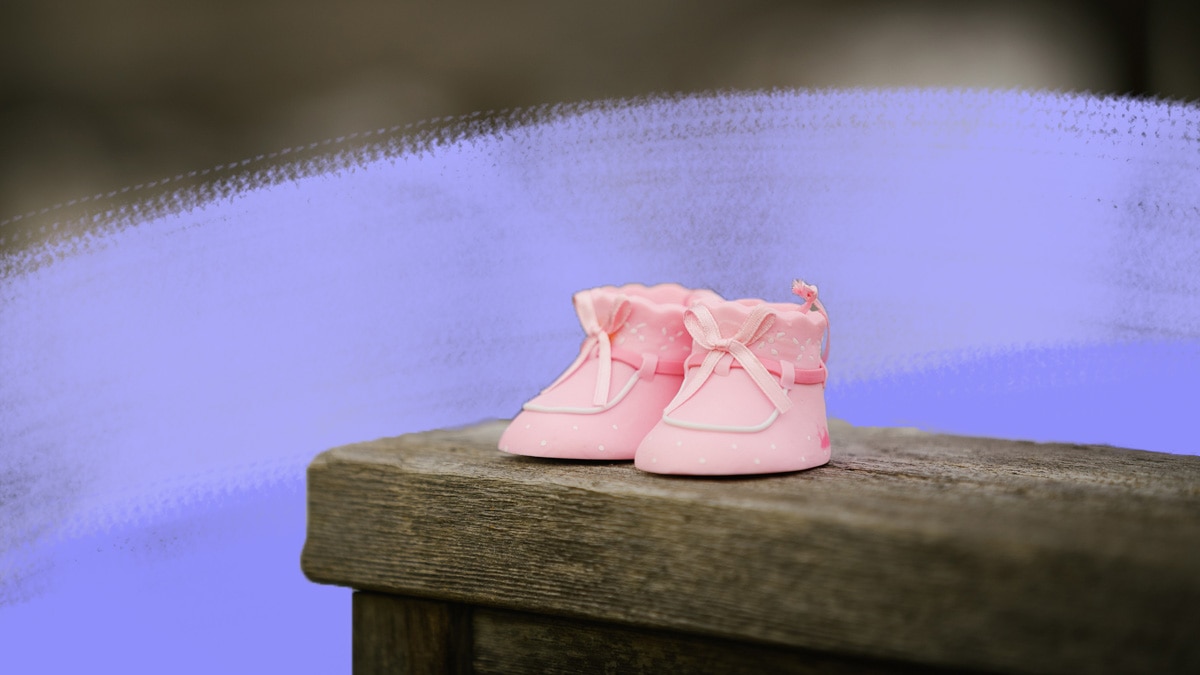 Pink baby shoes on wooden bench
