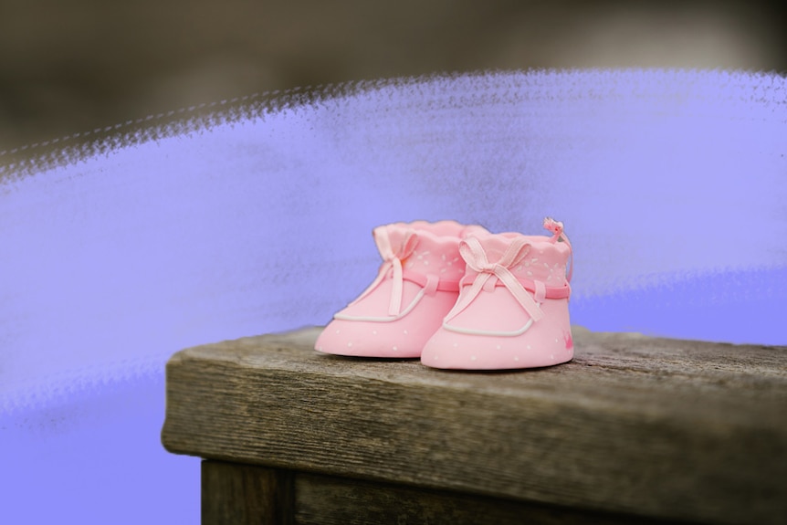 Pink baby shoes on wooden bench