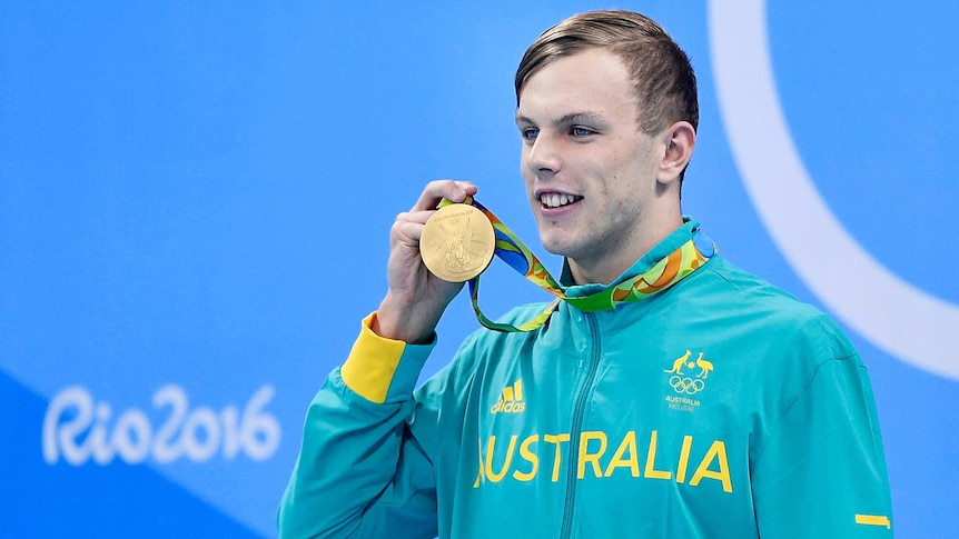 Kyle Chalmers holds medal close to face