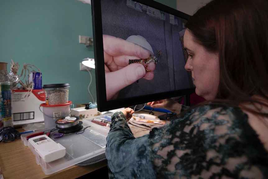 Visually impaired beader Asha Martin uses a video screen to enhance vision of her beading work.