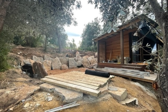 Wooden out house surrounded by buiding materials 