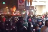 Video footage shows crowds of Iranian protesters fleeing  as police use tear gas to disperse them.