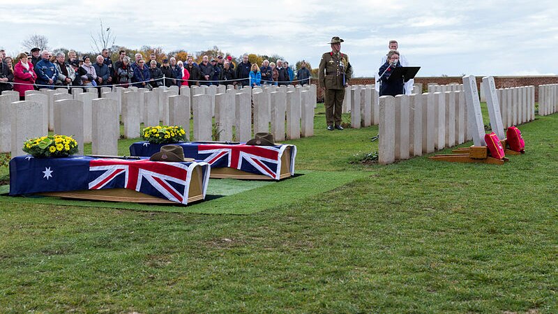 Two coffins draped in Australian flags at a cemetery
