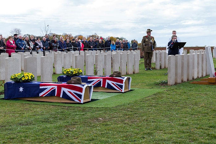 Two coffins draped in Australian flags at a cemetery