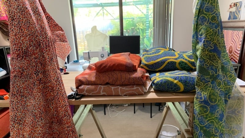 Blue and yellow fabric, red and orange, folded and draped over a table