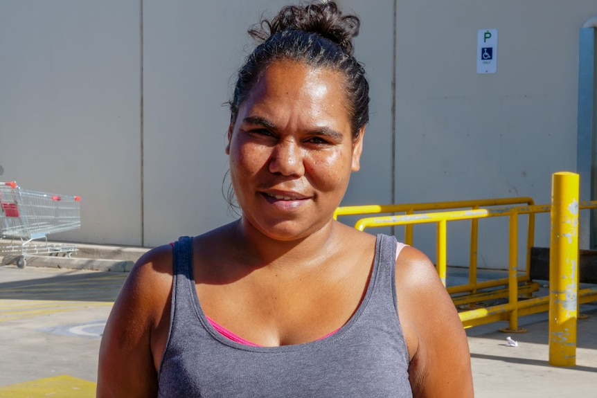 A woman standing in front of a supermarket.