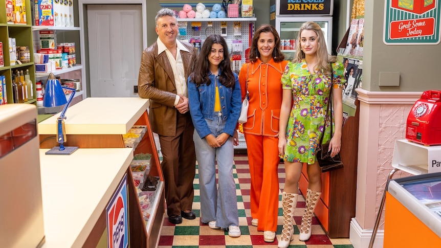 A family of four stand in 1950s clothing in a corner shop