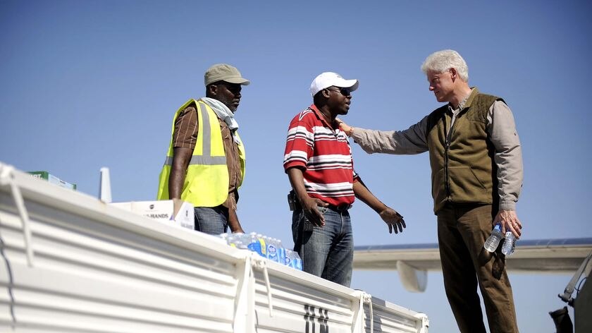 The former president of the United States, Bill Clinton, speakes with Haitian workers