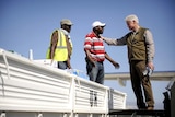 The former president of the United States, Bill Clinton, speakes with Haitian workers