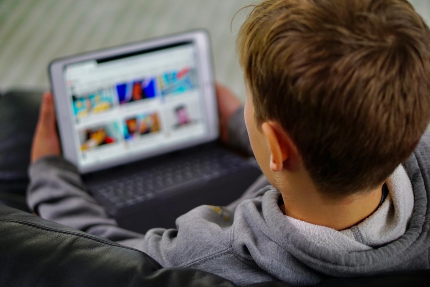 A boy plays on an iPad