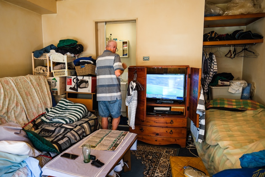 A man walks around his living room