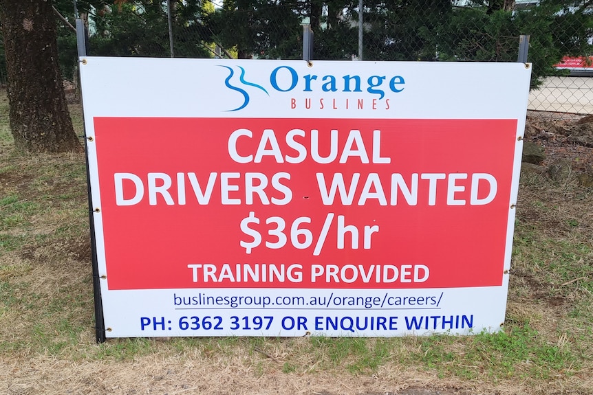 A red sign with casual drivers wanted in bold white writing 
