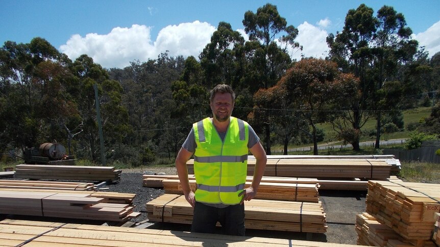 Timber mill operator Matthew Torenius stands amongst stacks of timber at his Forcett mill in southern Tasmania