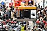 Airline passengers queue beside rows of luggage