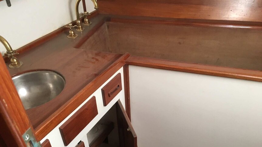 A bath set inside cabinetry next to a sink.