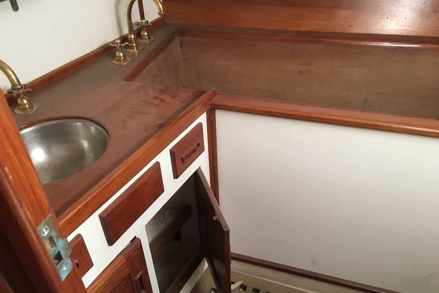 A bath set inside cabinetry next to a sink.