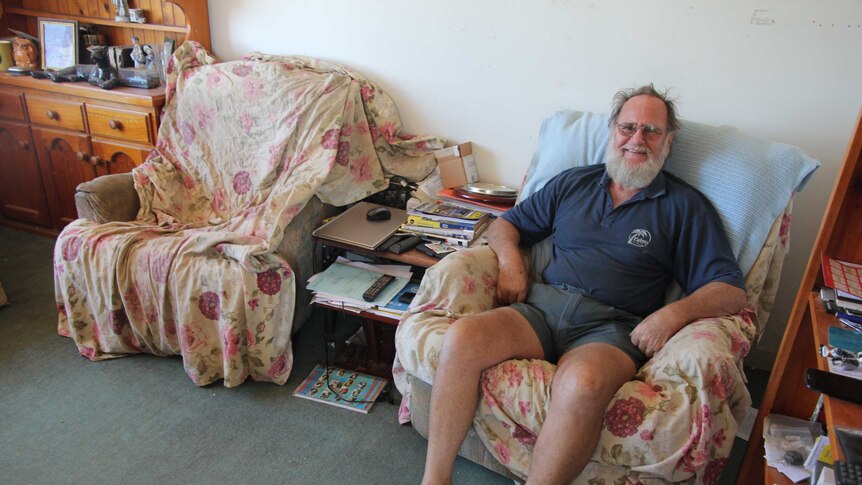 A man sitting in his living room on a lounge chair