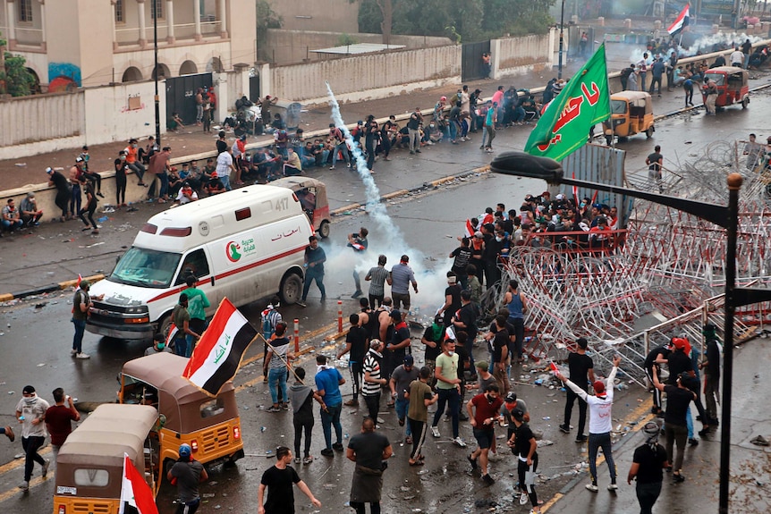 Iraqi security forces fire tear gas to disperse anti-government protesters during a demonstration in central Baghdad