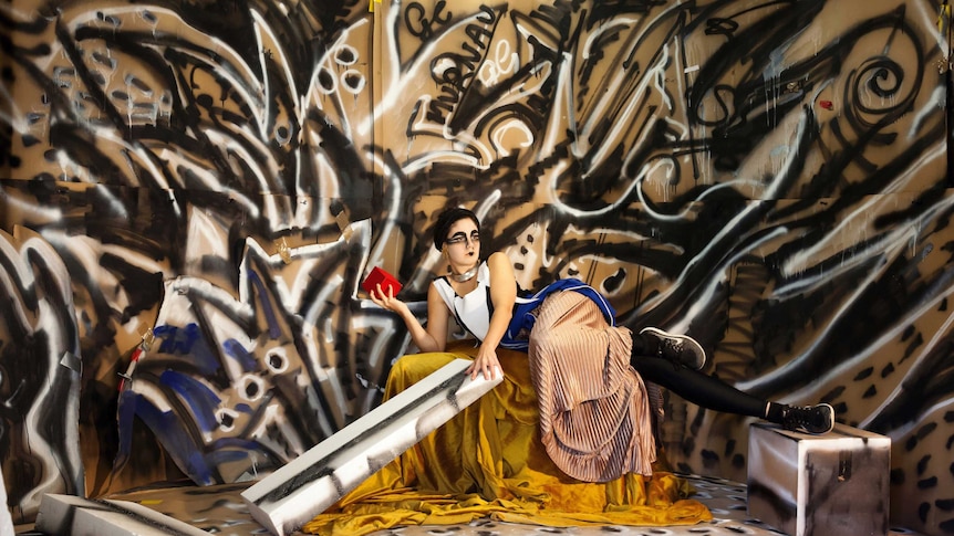 A art work featuring graffitied walls and a mannequin lounging