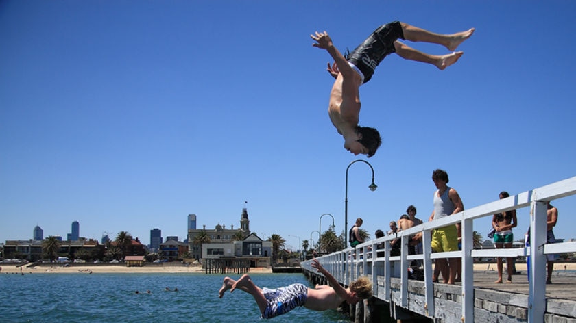A boy leaps into the sea from Middle Park pier
