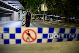 a nsw police officer stands near police tape outside blacktown police station at a crime scene 