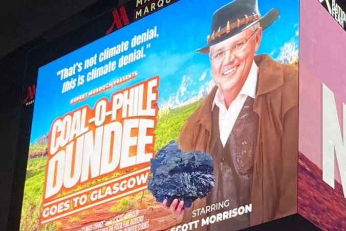 A billboard ad shows Scott Morrison dressed as Crocodile Dundee next to text saying: "Coal-o-phile Dundee goes to Glasgow"