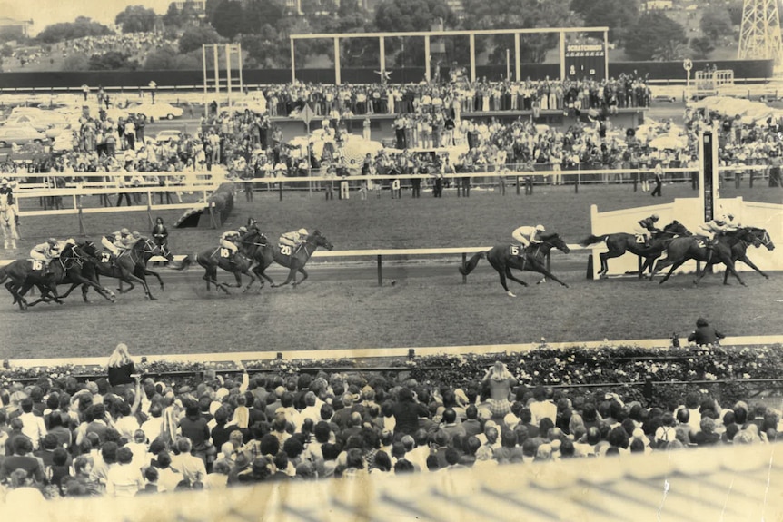 A black and white photo of a horse race