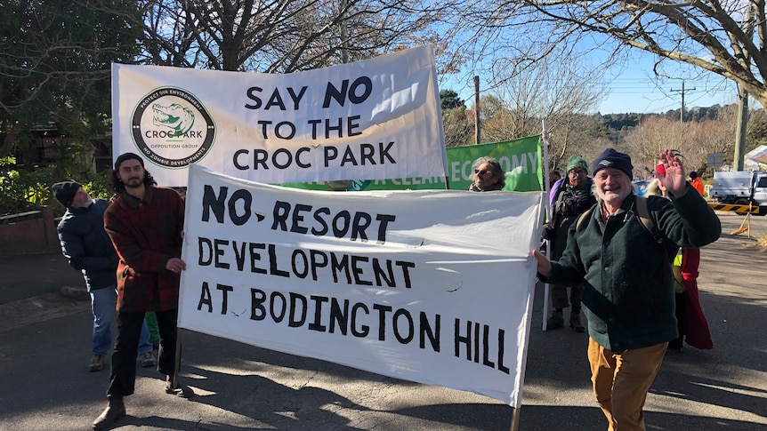 People hold banners including one that says "say no to the croc park"