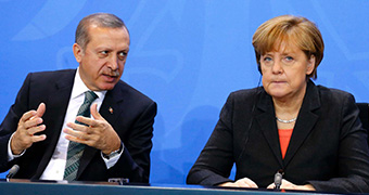 Turkish President Tayyip Erdogan and German Chancellor Angela Merkel sit next to eachother.
