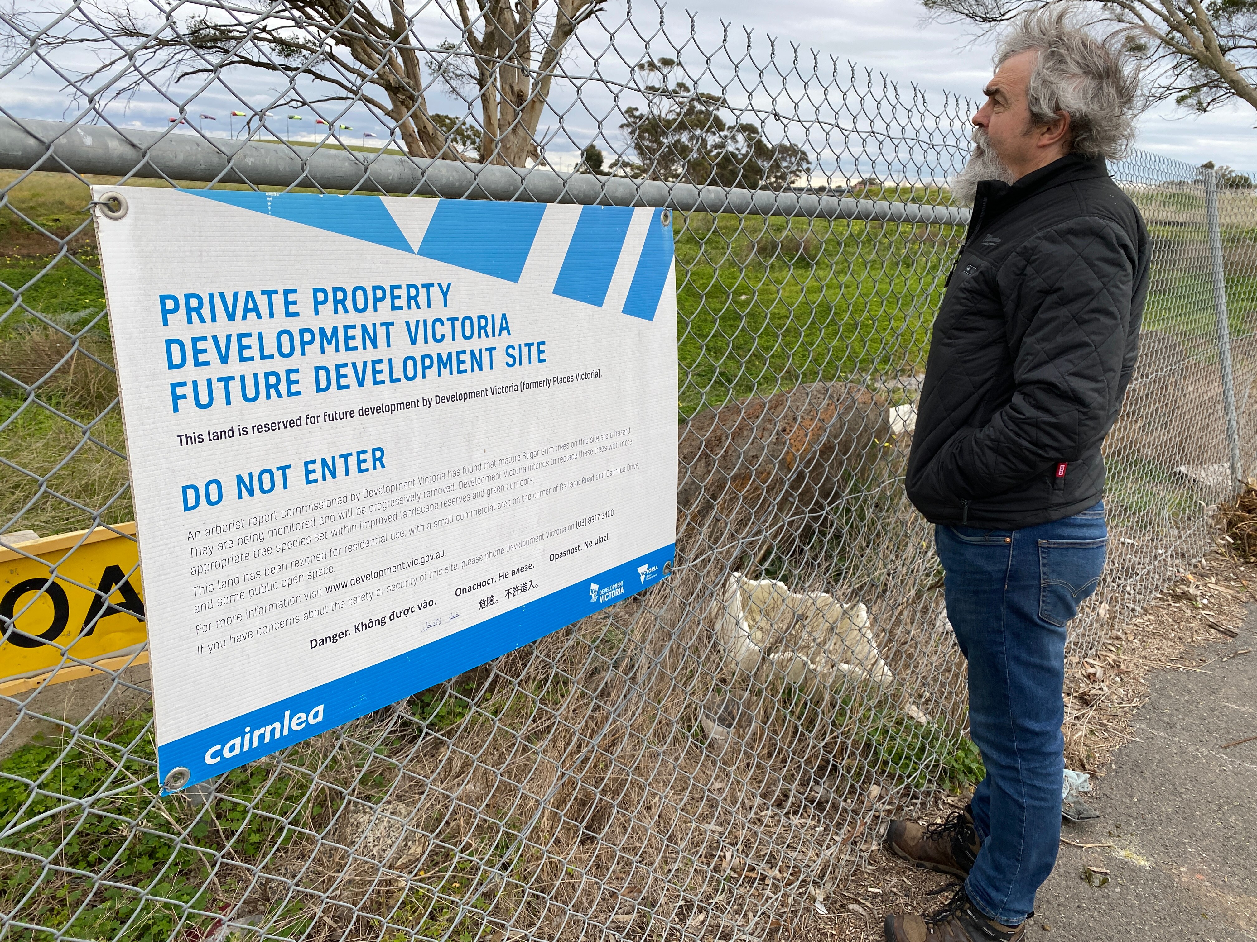 A man in front of a fence with a sign stating it is private property