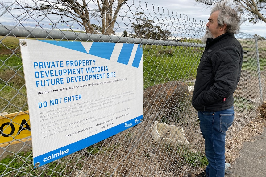A man in front of a fence with a sign stating it is private property