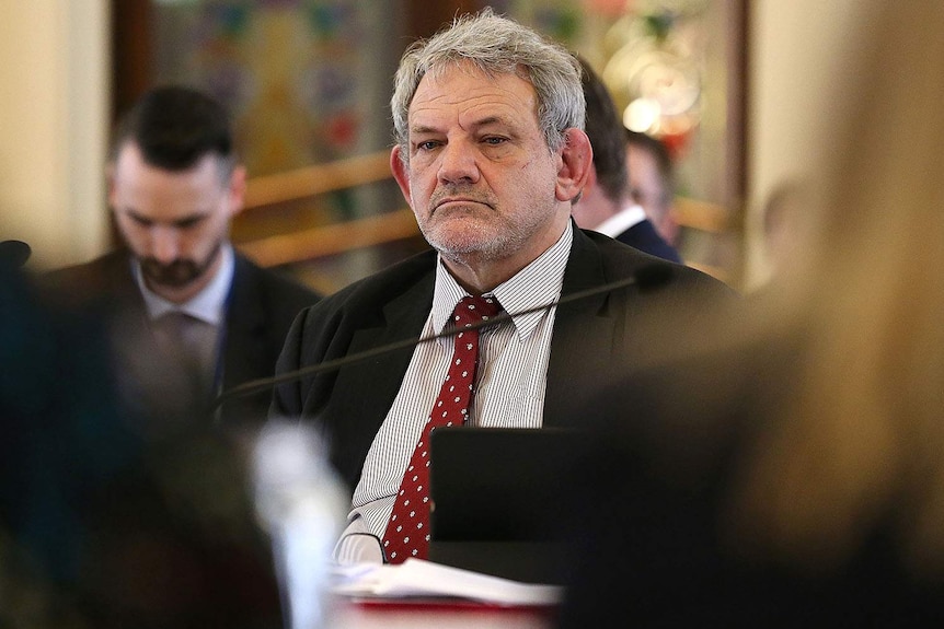 David Barbagallo sits at a table during estimate hearings at Queensland Parliament.