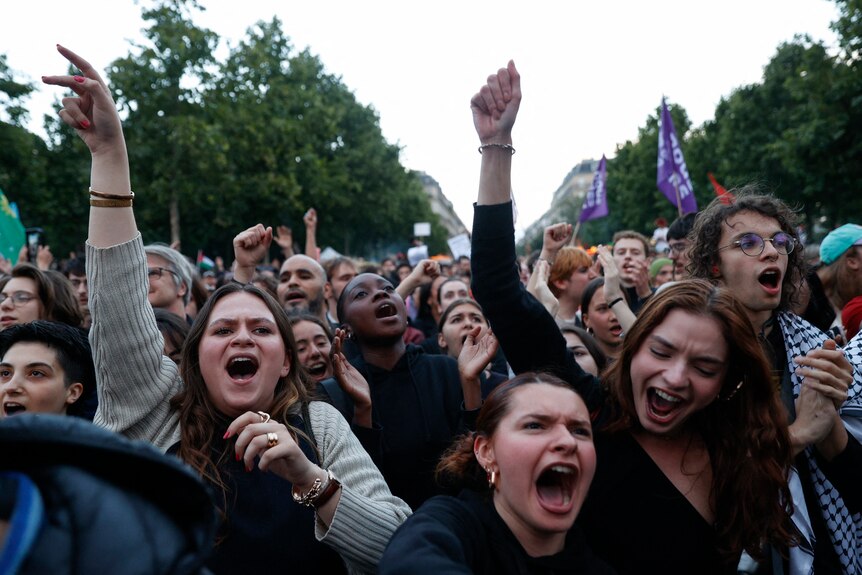 Members of a crowd react in joy after an election result in France