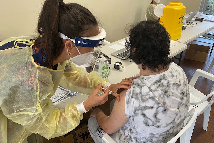 A nurse injects a vaccine into the arm of a patient.