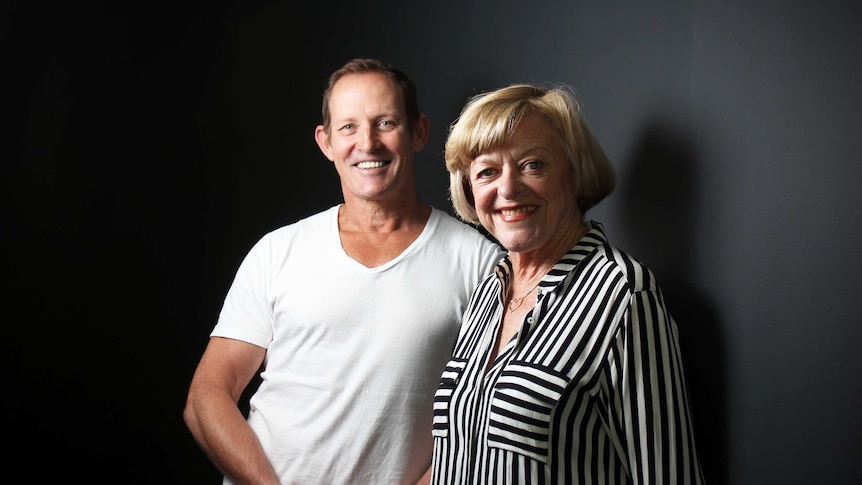 Todd McKenney and Nancye Hayes stand side by side smiling at the camera.